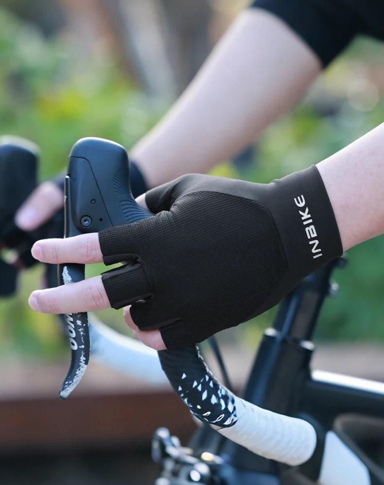 Person wearing a black bike glove on a blurred background of a bicycle.